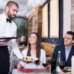 92841670-waiter-worker-male-bringing-food-for-people-of-adult-smiling-visitors